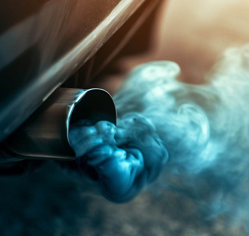 exhaust pipe of a car emitting bluish gray smoke